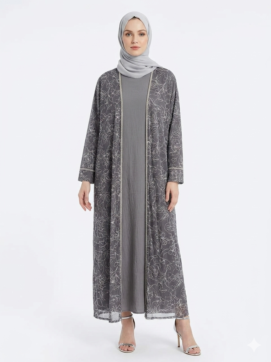 Fair-skinned model with grey eyes wearing the Rizqé Silver Flora embroidered sheer grey kimono abaya with a matching grey inner dress and scarf against a solid white studio background.